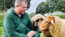 Michael Stücke streichelt Schafe.