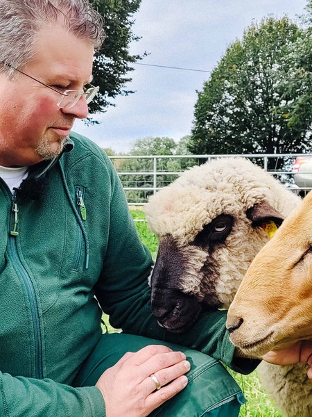 Michael Stücke streichelt Schafe.