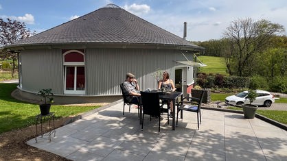 Jan Schurna und Eva Guntermann sitzen auf der Terasse vor ihrem Haus in Edelkirchen.