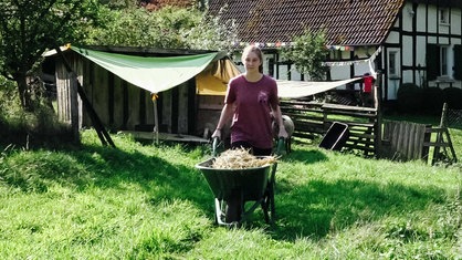 Elena Kropp schiebt eine Schubkarre