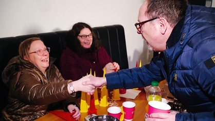 Reporter Oliver Köhler gibt einer der am Projekt beteiligten Frauen die Hand.