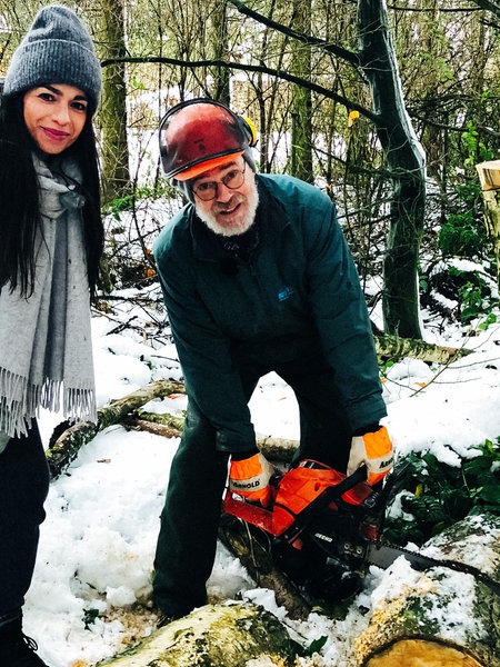 Lokalzeit-Moderatotin Jennifer Jermoin mit einem der ehrenamtlichen Helfer, der gerade einen Baum mit einer Motorsäge zerkleinert, im Freibad Vossenack.