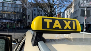 Nahaufnahme eines Taxischildes auf einem Taxi