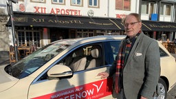 Taxifahrer Rolf Golischewski steht neben seinem Taxi