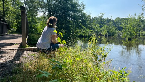 Eine Frau schaut auf den Borner See