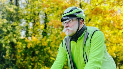 Max Holz fährt mit seinem Fahrrad durch einen Wald.