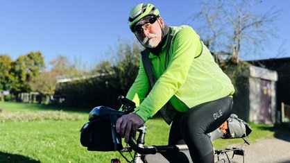 Max Holz sitzt in voller Montur auf seinem Fahrrad