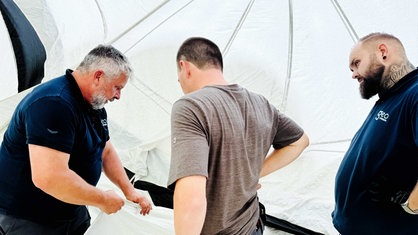 Das Ballon-TÜV-Team kontrolliert den Stoff des Heißluftballons. Frank Zinkler hält dazu eines der Seile in der Hand