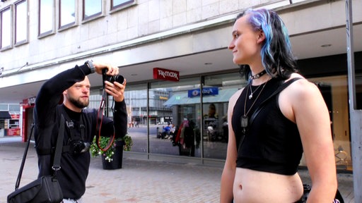 Streetstyle-Fotograf Eric Huy bei der Arbeit mit seiner Kamera und einer Person mit bunten Haaren, die für ihn posiert