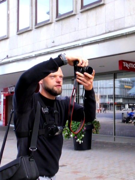Streetstyle-Fotograf Eric Huy bei der Arbeit mit seiner Kamera und einer Person mit bunten Haaren, die für ihn posiert