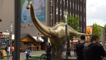 Eine lebensgroße Dinosaurier-Figur steht in der Bochumer Innenstadt