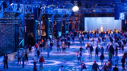 Menschen fahren auf der Eisbahn in der Jahrhunderthalle in Bochum Schlittschuh