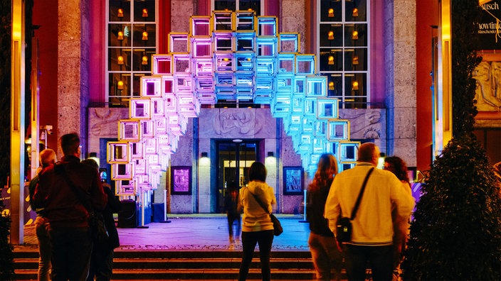 Besucher schauen sich eine Lichtinstallation vor dem Grillo-Theater in Essen an.