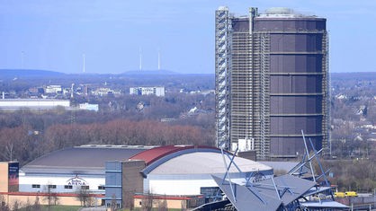 Der Gasometer in Oberhausen von außen, im Vordergrund die Konzerthalle am Centro, im Hintergrund ein weiter Blick über das Ruhrgebiet.