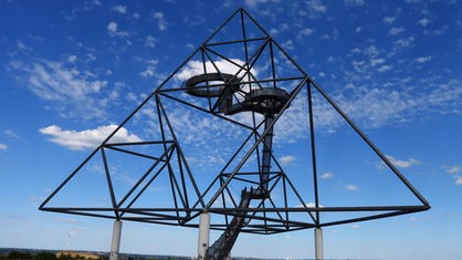 Die pyramidenförmige Stahlskulptur Tetraeder in Bottrop vor blauem Himmel