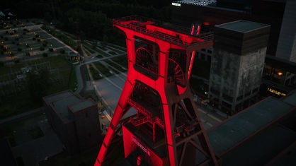Der rot angestrahlte Doppelbock der Zeche Zollverein in Essen von oben bei Nacht
