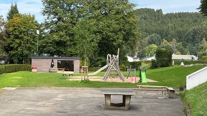 Kids Club mit Holzhaus, Rutschen, Sandkasten und Tischtennisplatte auf dem Gelände des Campingplatzes