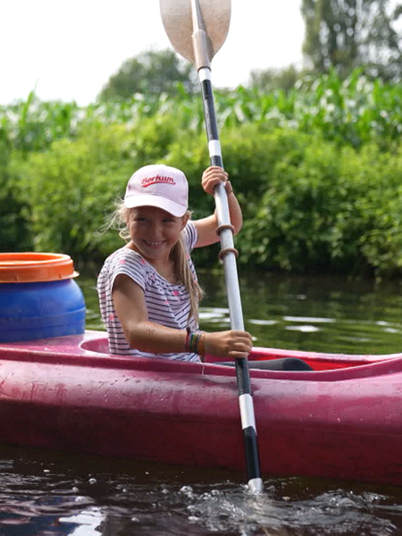 Ein Mädchen und ihr Vater paddelnd auf einem Fluss.