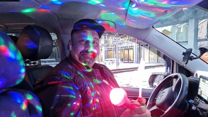 Kürsat Isikoglu mit einem leuchtenden Stab in seinem Party-Taxi