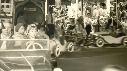 Ein Schwarz-Weiß-Foto zeigt Kinder auf einem Karussell der Haaner Kirmes.