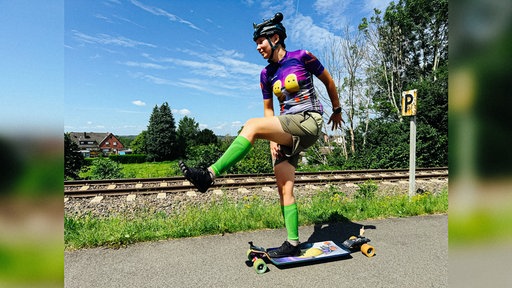 Eine junge Frau fährt auf ihrem Longboard