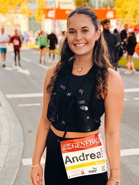 Eine junge Frau steht am Zieleinlauf des Köln-Marathons.