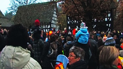 Kinder und Erwachsene stehen auf einem Platz im Freilichtmuseum