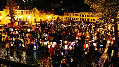 Familien und Kinder stehen mit Laternen auf dem Klosterplatz in Bad Münstereifel