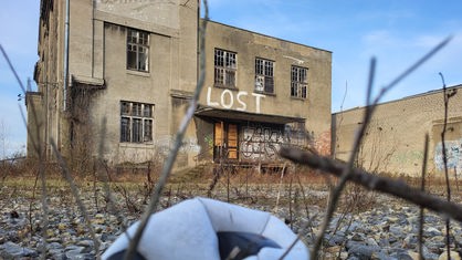 Die verlassene Schokoladenfabrik im Hintergrund, ein luftloser Fußball im Vordergrund