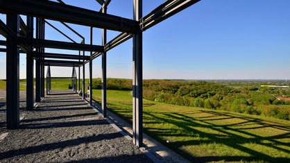 Der Ausblick von der Halde Norddeutschland auf den Niederrhein. Außerdem sind Stahlträger der Installation "Hallenhaus" links im Bild