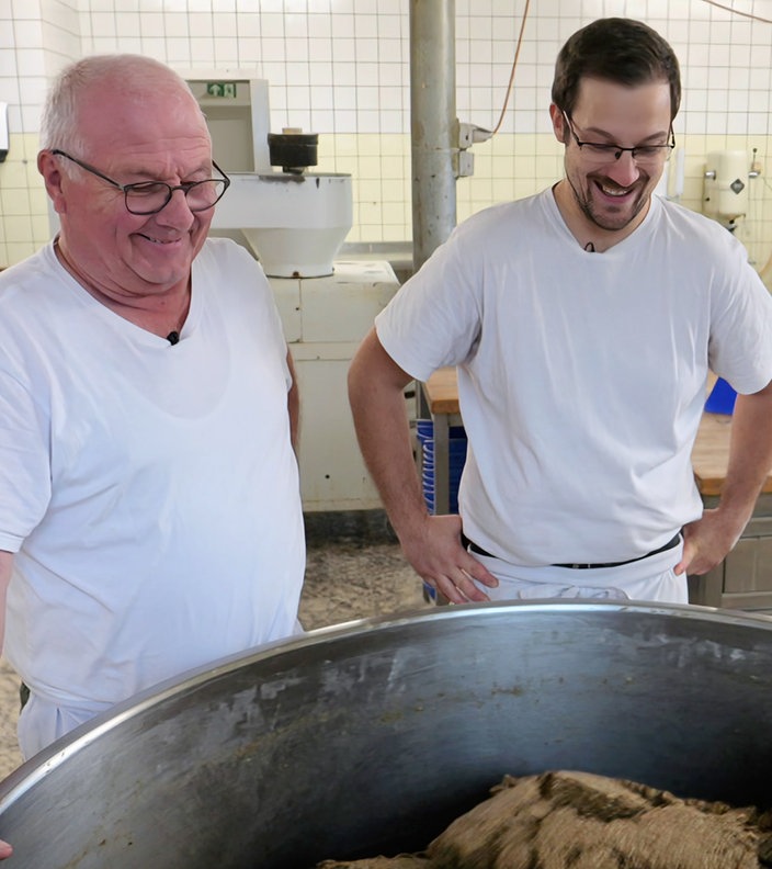 Zwei Männer stehen an einer Brotmaschine