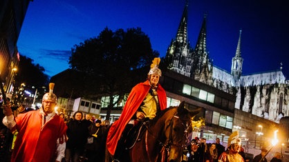 Der "Heilige Sankt Martin" reitet bei einem Martinszug am Kölner Dom vorbei