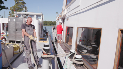 Schiffsführer Frank Sommer zieht das Boot eines Kunden an sein Bunkerschiff