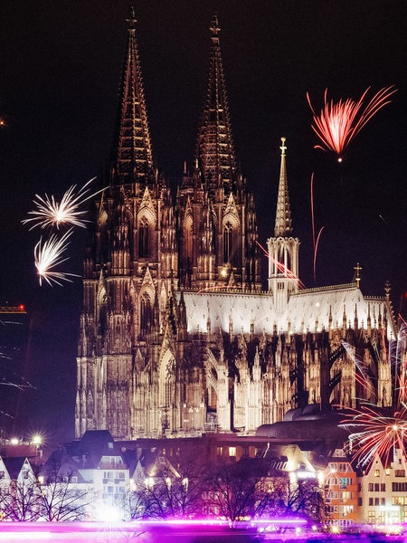 Der Kölner Dom an Silvester, es sind zahlreiche Feuerwerke zu sehen