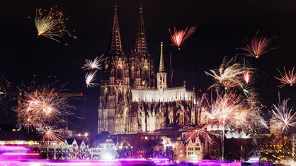 Der Kölner Dom an Silvester, es sind zahlreiche Feuerwerke zu sehen