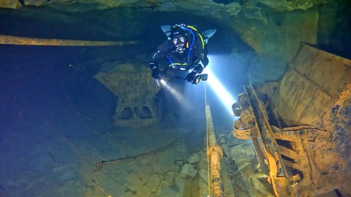 Eine Taucherin taucht durch das Bergwerk in Bestwig-Nuttlar