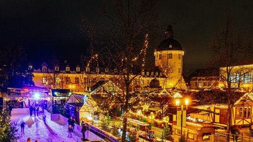 Weihnachtsmarktszenerie am Unteren Schloss in Siegen mit dem Schlossturm im Hintergrund.