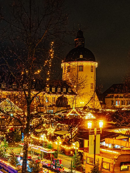 Weihnachtsmarktszenerie am Unteren Schloss in Siegen mit dem Schlossturm im Hintergrund.