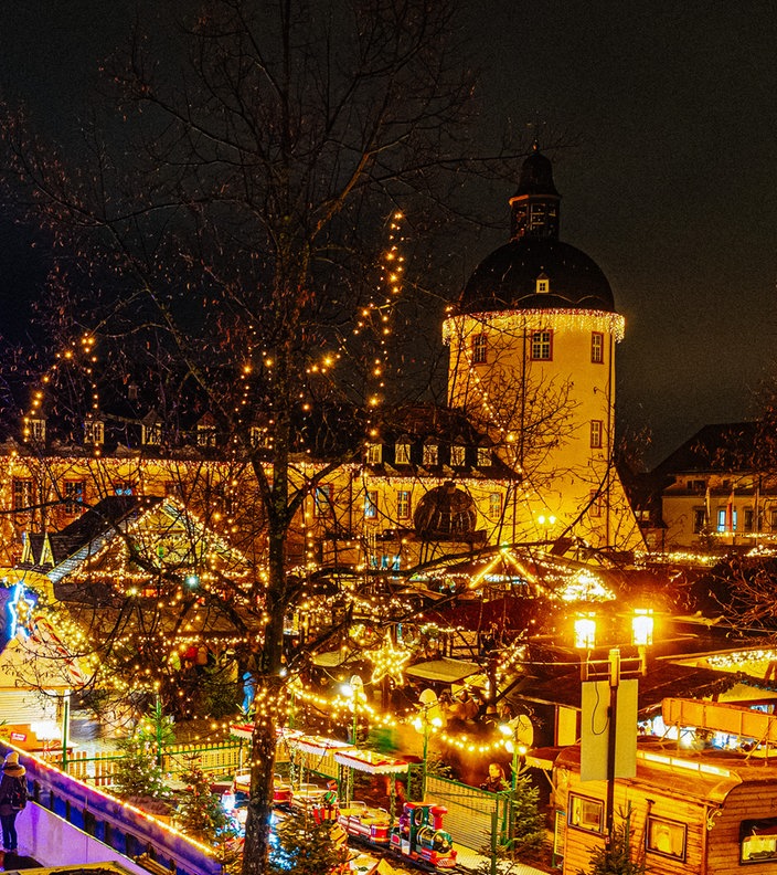 Weihnachtsmarktszenerie am Unteren Schloss in Siegen mit dem Schlossturm im Hintergrund.