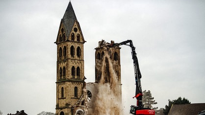 Zwei Bagger stehen vor der ehemaligen Kirche. Es steht nur noch einer der beiden Türme.