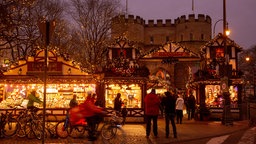 Eine leuchtende Hütte im Fachwerkstil auf dem Weihnachtsmarkt in Köln