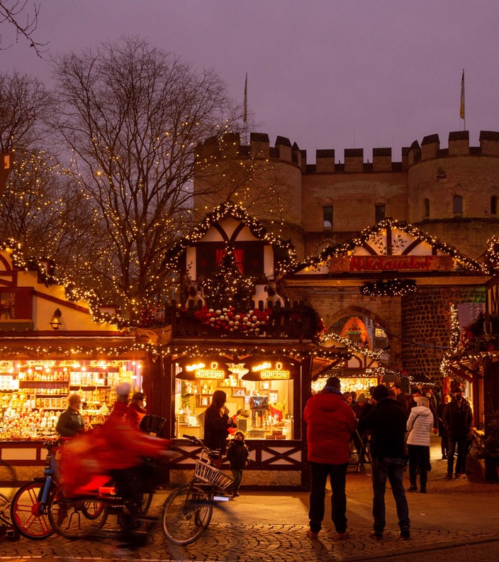 Eine leuchtende Hütte im Fachwerkstil auf dem Weihnachtsmarkt in Köln