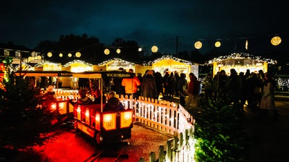 Blick auf die Wichtelbahn am Weihnachtsmarkt Schloss Benrath, im Hintergrund Stände