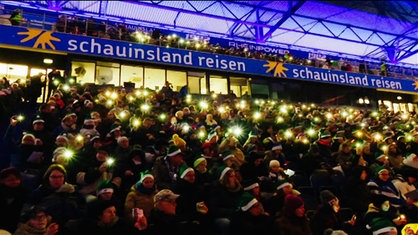 Menschen singen gemeinsam im Duisburger Stadion.