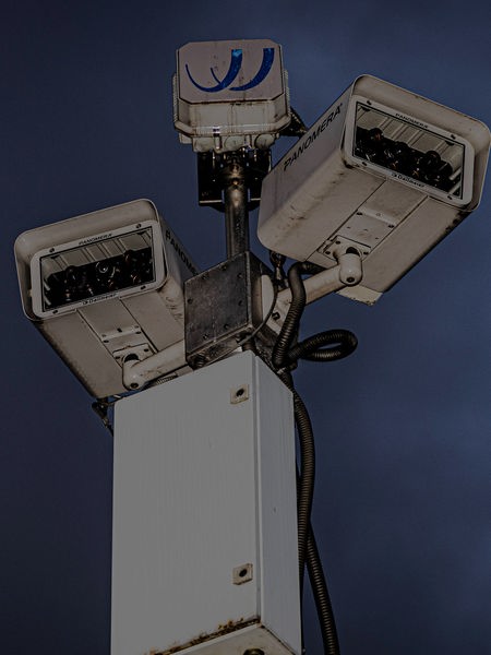 Eine Überwachungskamera vor einem dunklen Himmel.