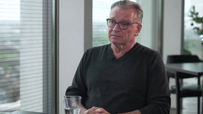 Wolfgang Kaes sitzt an einem Tisch und gibt ein WDR-Interview