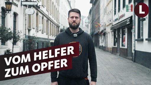 Ein Mann steht in der Düsseldorfer Altstadt und guckt in die Kamera. Auf dem Foto der Schriftzug "Vom Helfer zum Opfer"