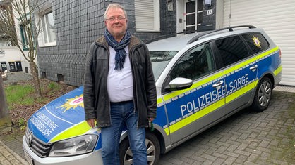 Seelsorger Michael Clauß vor einem Polizeiauto