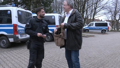 Seelsorger Michael Clauß gibt Polizist Süßigkeiten