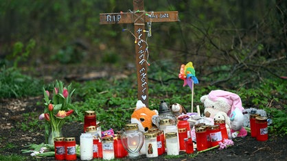 An der Stelle, an der das getötete neugeborene Mädchen in Mönchengladbach gefunden wurde, stehen ein Kreuz, Kerzen und Stofftiere